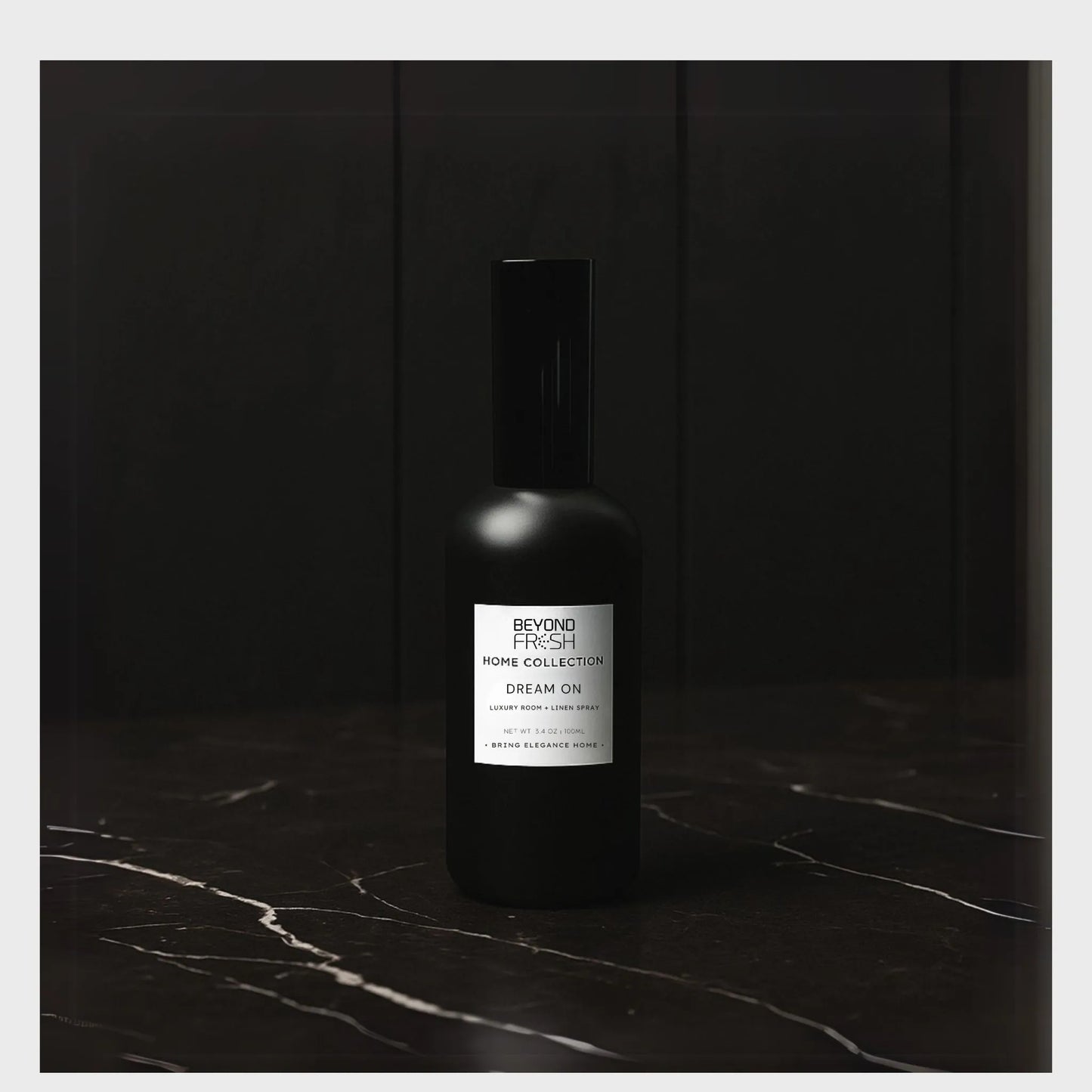 100 ml black bottle of Home Collection Room Spray, Dream On scent on a dark marble surface