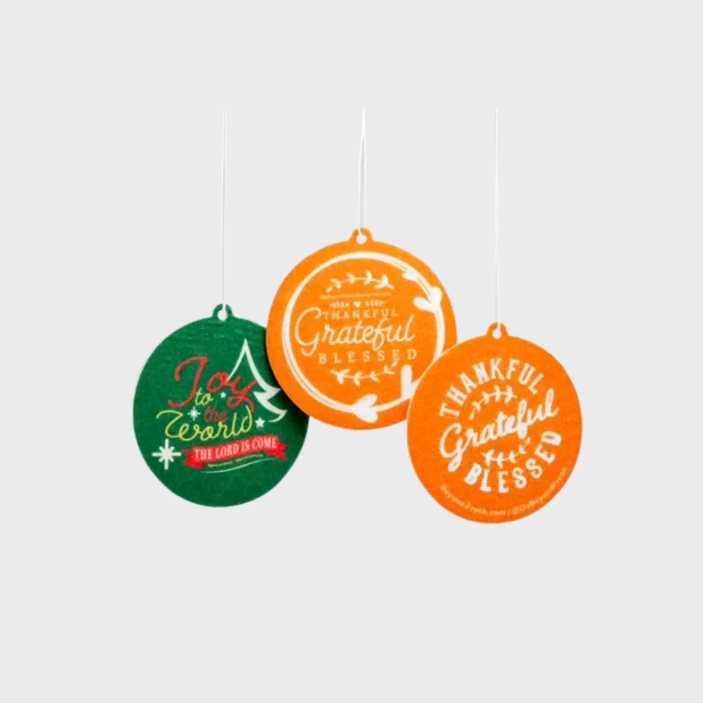 Three Christmas-themed reusable scent tags with motivational phrases on a white background.
