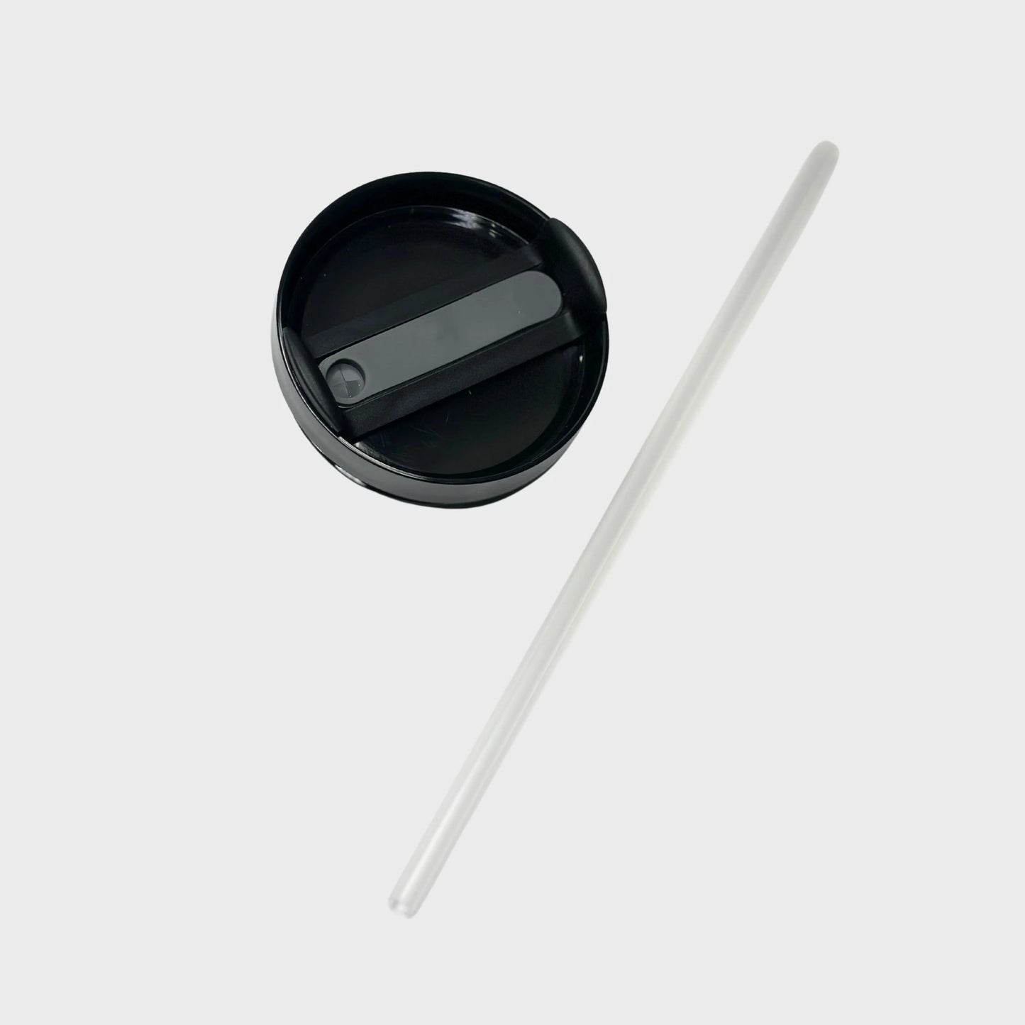 Black lid of tumbler and a transparent straw on a white background