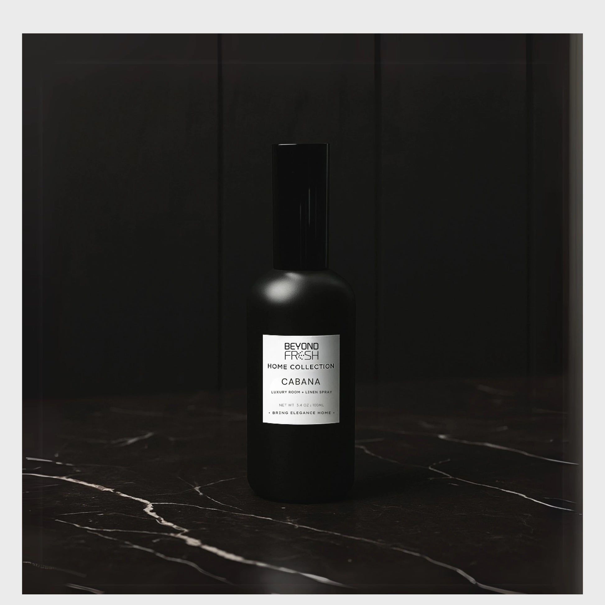 Black bottle of room spray with a white Beyond Fresh label on a dark marble surface