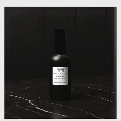 Black bottle of room spray with a white Beyond Fresh label on a dark marble surface