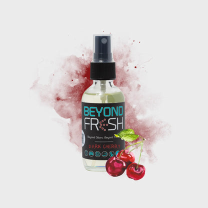 Bottle of Beyond Fresh Dark Cherry spray with cherries and mint leaves on a light background