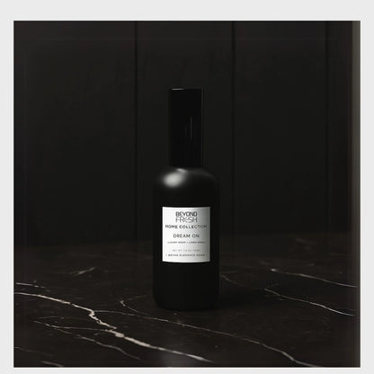 100 ml black bottle of Home Collection Room Spray, Dream On scent on a dark marble surface