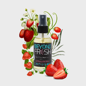 Bottle of strawberry-scented spray surrounded by strawberries and green leaves on white background.
