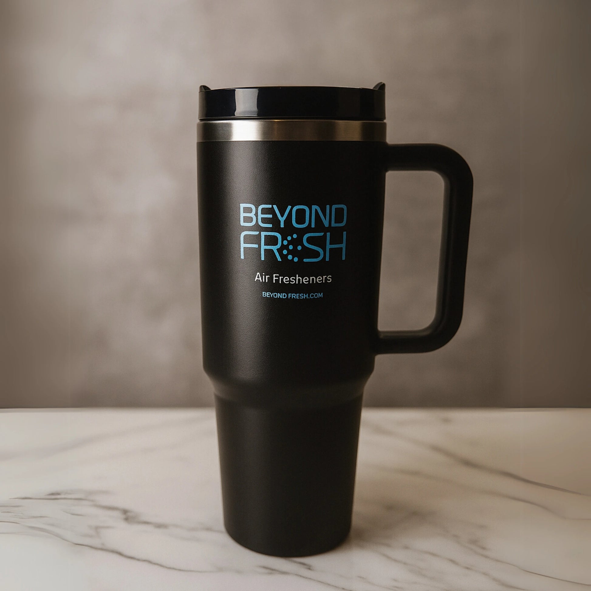 Black travel tumbler with 'Beyond Fresh' branding on a marble surface.